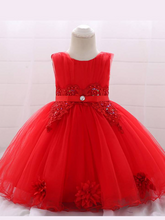Load image into Gallery viewer, Baby dress has a tulle overlay with flower applique and a satin belt with rhinestone detail-red
