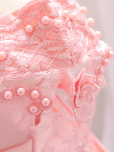 Load image into Gallery viewer, Baby dress has a satin embroidered bodice with pearl details and capped sleeves, a bow belt at the waist, and a tulle skirt with flower applique