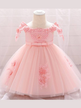 Load image into Gallery viewer, Baby dress has a satin embroidered bodice with pearl details and capped sleeves, a bow belt at the waist, and a tulle skirt with flower applique