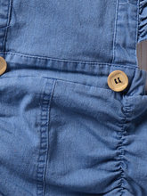 Load image into Gallery viewer, Baby overall style romper onesie has ruffled shoulder straps that tie on the back. has 2 little buttons on the front to make it even more stylish