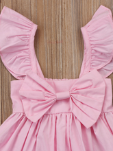 Load image into Gallery viewer, Baby apron style dress has a ruffled adjustable straps and a stretchy bodice with a big bow
