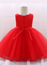 Load image into Gallery viewer, Baby dress has a tulle overlay with flower applique and a satin belt with rhinestone detail-red
