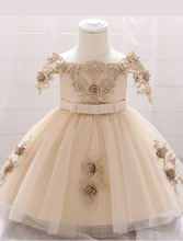 Load image into Gallery viewer, Baby dress has a satin embroidered bodice with pearl details and capped sleeves, a bow belt at the waist, and a tulle skirt with flower applique
