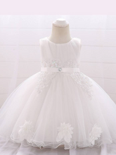 Load image into Gallery viewer, Baby dress has a tulle overlay with flower applique and a satin belt with rhinestone detail-white
