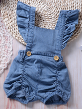 Load image into Gallery viewer, Baby overall style romper onesie has ruffled shoulder straps that tie on the back. has 2 little buttons on the front to make it even more stylish
