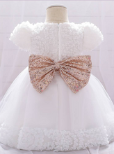 Load image into Gallery viewer, Baby dress has a floral bodice, a tulle skirt with floral hem, and a gold sequin belt with bow at the front and back
