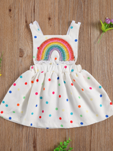 Load image into Gallery viewer, Baby white dress has a colorful polka dot print and rainbow applique pullover style ties at the back
