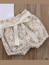 Load image into Gallery viewer, Baby set features a short-sleeved onesie with a crochet ruffle at the shoulder and embroidered shorts with a sash
