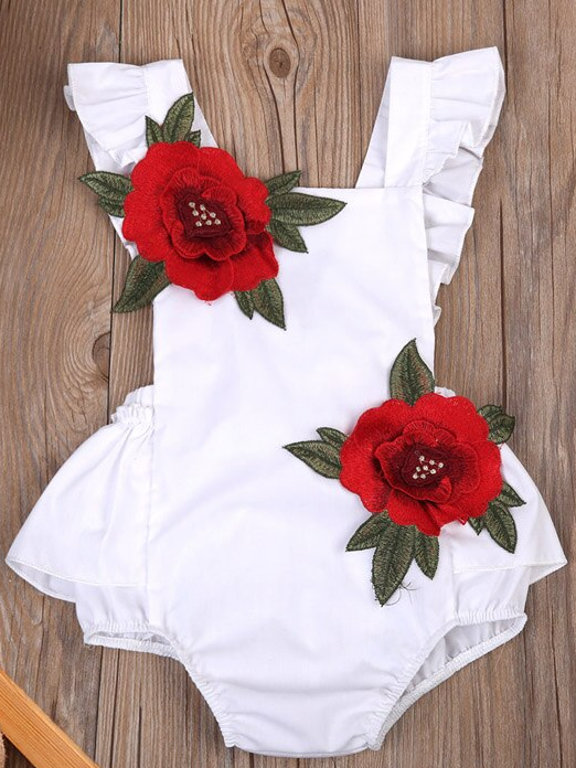 Baby little onesie has big red flower appliques and ties at the back for easy slip-on white